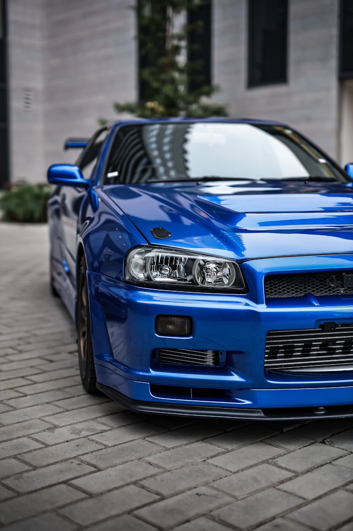 Experience the sleek and modern design of a vibrant blue sports car in an urban setting.