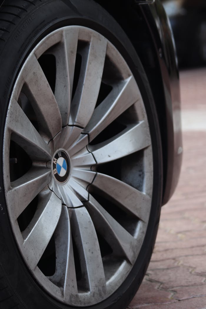 Detailed view of a car's alloy wheel parked on a city street.