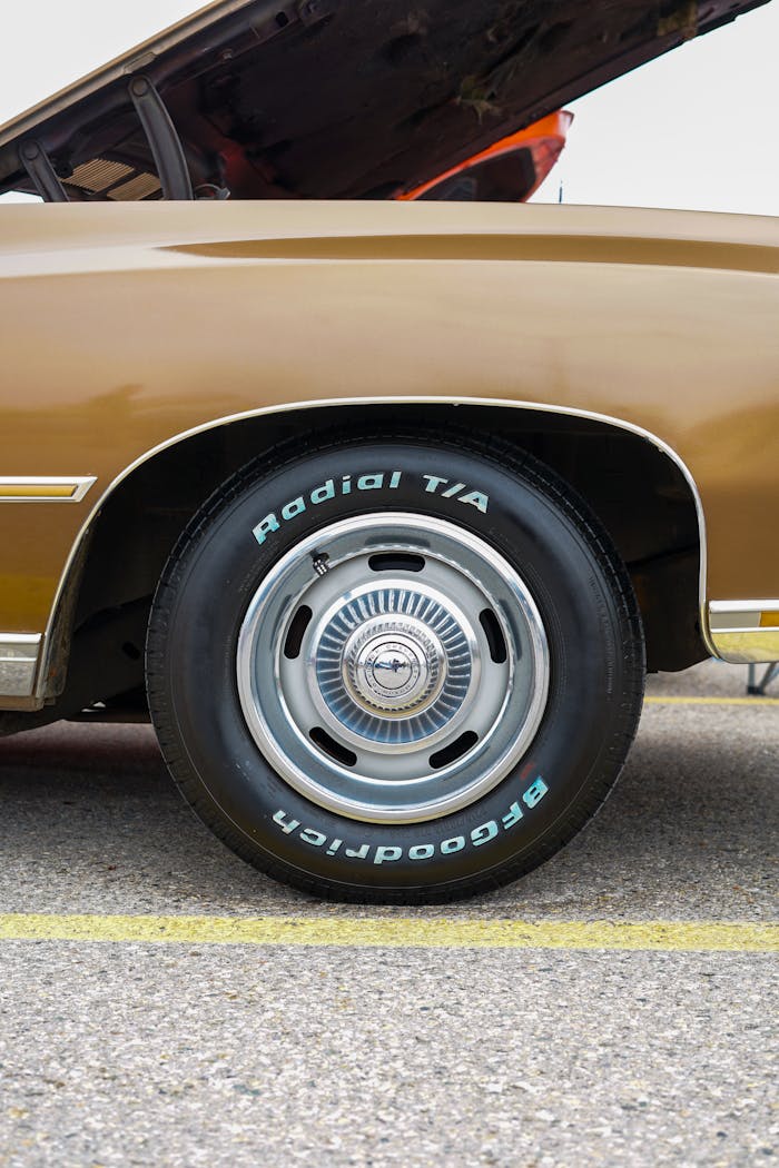 Detailed view of a vintage car's tire and open hood. Perfect for automotive enthusiasts.